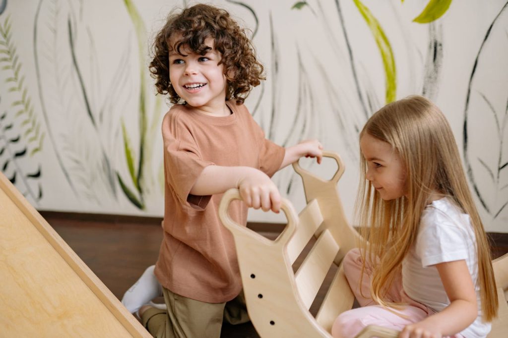 Two young children enjoy a fun and playful moment indoors with a wooden toy in a creative playroom setting.